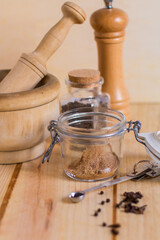 Measuring spoons and other kitchen utensils with spices, with neutral textures and colors against wooden background