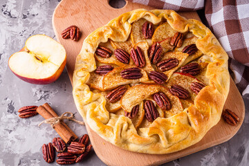 crispy apple galette with pecans on a rustic wooden background