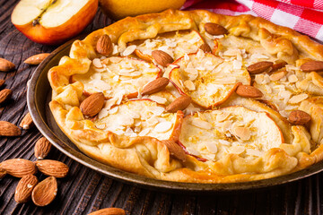 crispy apple galette with almonds on rustic wooden background