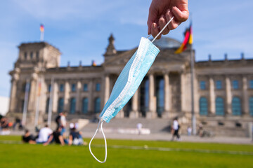 Medical mask removed from face with the German Bundestag in the background. End of quarantine