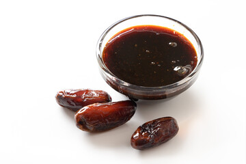 Dates jam in glass bowl without sugar and fruits isolated on white. Close up.