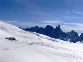 Fototapeta na wymiar View from the top of Alpe Lusia ski area with rocky mountains and small wooden cottage in Italy 
