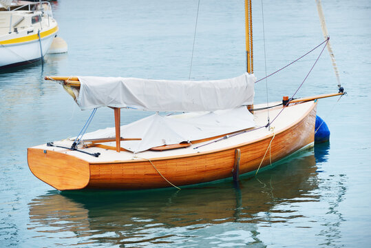An elegant old gaff rigged classic boat anchored on mooring near the ocean shore, close-up. Brittany, France. Transportation, sailing, racing, regatta, sport and leisure activity, vacations, cruise