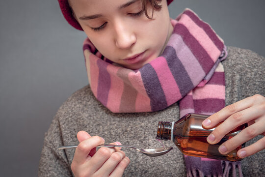 Young Man Taking Medicine, Boy Pours Cough Syrup Into Spoon, First Symptoms Of A Cold