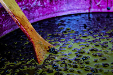 A wooden spoon in a pot where is chokeberry jam. The process of preparing chokeberry (aronia) jam.