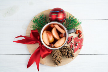 Beautiful Christmas composition with a Cup of mulled wine in the middle, surrounded by Christmas decorations on a white wooden background. Holiday background. The concept of New year and Christmas.