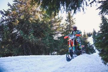 Snowbike rider in mountain valley in beautiful snow powder. Snowdirt bike with splashes and trail. Snowmobile winter sport riding