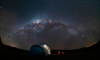 An amazing night sky at Atacama Desert. A tent, a campfire and the milky way over us, just an awe nightscape over our base camp inside Atacama arid desert. Amazing view over Sagittarius night stars - obrazy, fototapety, plakaty