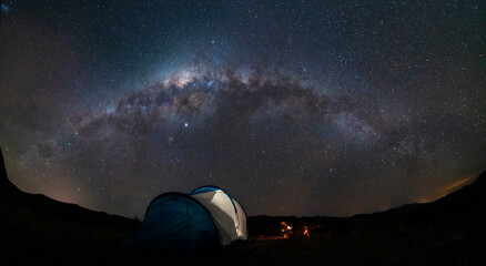 An amazing night sky at Atacama Desert. A tent, a campfire and the milky way over us, just an awe nightscape over our base camp inside Atacama arid desert. Amazing view over Sagittarius night stars