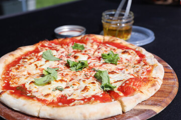 Pizza en gros plan déposée sur une table avec une nappe noire