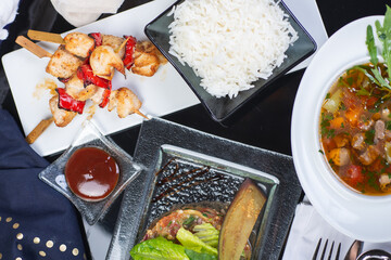 Top view of a restaurant table served with a multi-course set lunch and drink. Complex lunch.