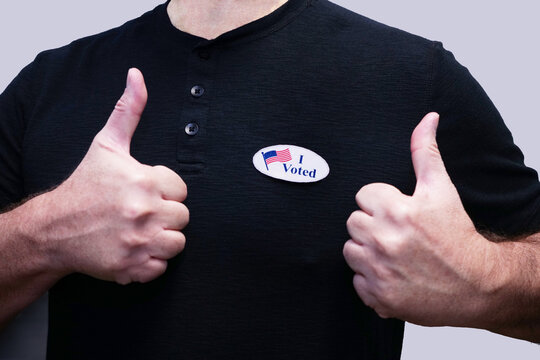 Closeup Torso Of Man In Black Shirt Wearing I Voted Sticker Giving Thumbs After Voting.