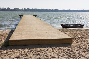 drewniany pomost i łódka nad jeziorem