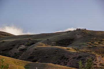 Scenery of green naked hills under the blue evening sky
