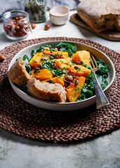 Season salad with grilled pumpkin, kale, chickpea, pepitas and nuts. Autumn vegetarian healthy recipe.