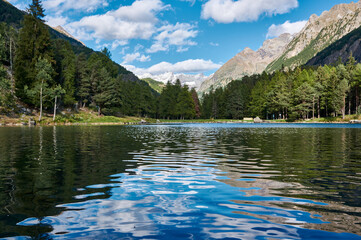 mountain lake with the reflection of the sky and mountains in the alps against the background of mountains with glaciers
