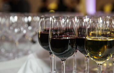 Verres à vin rouges et blancs déposés sur une table avec une nappe blanche 