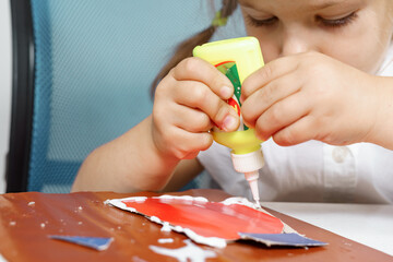 children's creativity. child glues colored paper