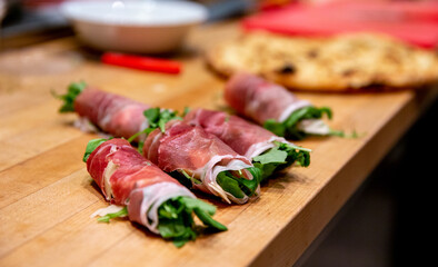 roulé de viande avec de la roquette au milieu sur le bord d'une table en bois