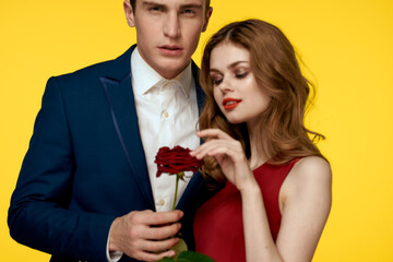 Lovers men woman with red rose in hands romance holidays yellow background family friends.