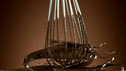 Fototapeta na wymiar Freeze motion of wire whisk rotating hot melted chocolate