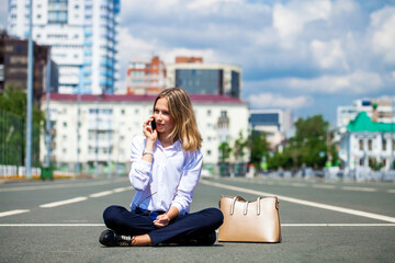 Young beautiful business woman sitting in the city square