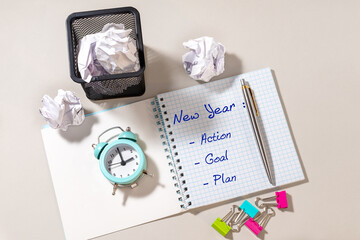 Pen, Notepad with new year, action, goal, plan and blue alarm clock on light background