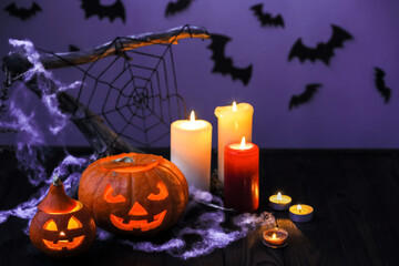 Halloween decor elements. Halloween pumpkins with candles, cobwebs, bats on a purple background. The layout of the poster for Halloween