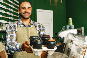 Portrait of a mixed race young man barista in coffee shop