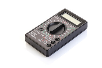 Digital electrical tester multimeter in black case isolated on white background. Digital multimeters have a numeric display, can measure voltage, current and resistance. Close-up. Full depth of field.