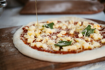 Colocando aceite de oliva a pizza napolitana