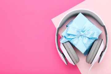 Headphones with gift box on colorful background