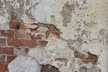 destroyed brick wall with fallen off plaster