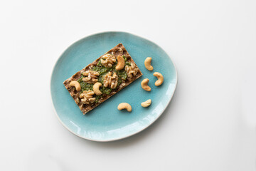 cracker with pesto and nuts on a plate