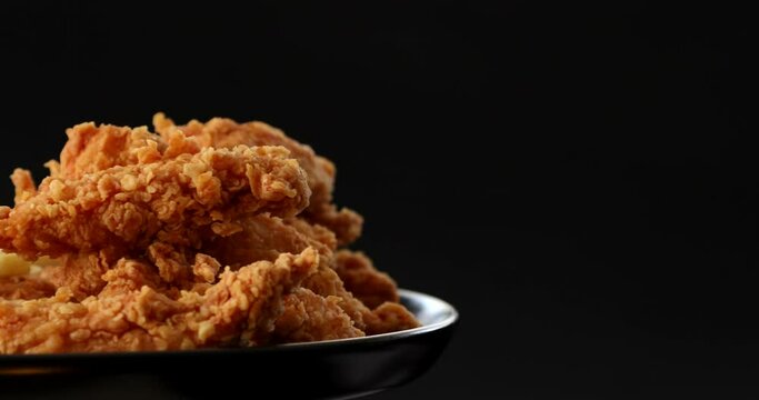 Macro view of Tasty french fries and crispy chicken nuggets with mustard and ketchup at black background