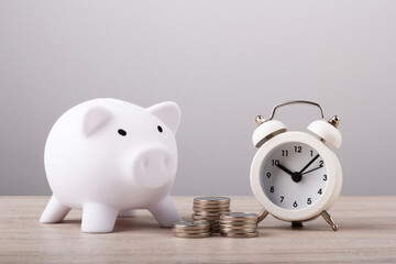 Piggy bank with coins and clock, business and finance concept.