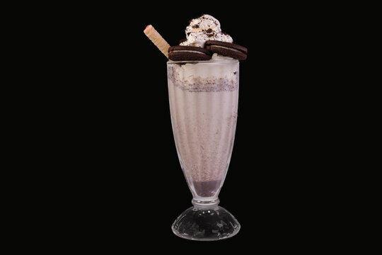 Delicious Milkshake garnish with whipped cream and biscuits in a glass,