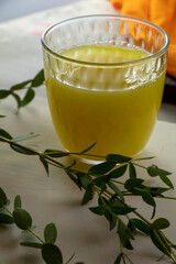 glass of juice and a branch of eucalyptus