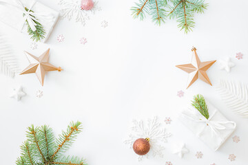 Flat lay frame with fir branches, christmas baubles decoration and gift box on a white background