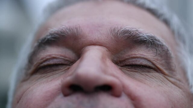 Middle aged man looking at sky, close-up senior eyes closing eyes in contemplation
