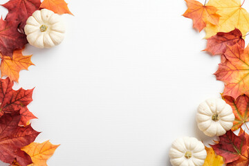 Autumn frame. Colorful maple leaves and pumpkins on white background. Flat lay, top view, copy space. Autumn fall, harvest, thanksgiving concept. - obrazy, fototapety, plakaty