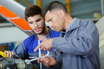 two mechanics working on a small aircraft