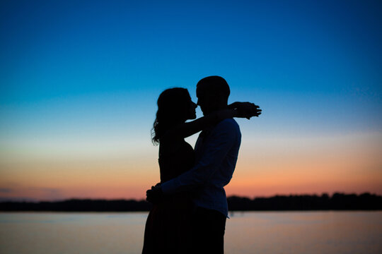 Silhouettes of a couple in love romance at sunset