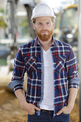 confident serious construction worker standing with hands in pockets