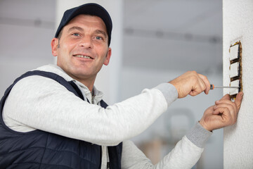 portrait of electrician standing next to socket