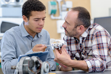 two men repairing electronic device