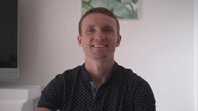 A young man is talking by video call with friends, colleagues, relatives. Communication in self-isolation.