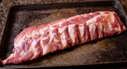Baby back ribs prepped on a sheet pan
