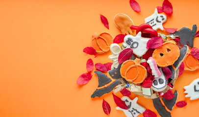 Halloween Jack o Lantern candy bowl with candy and halloween cookies Trick or Treat on orange background
