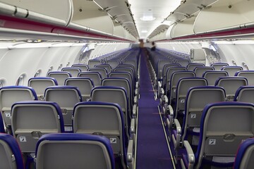 Airplane cabin interrior with empty seats, almost nobody onboard